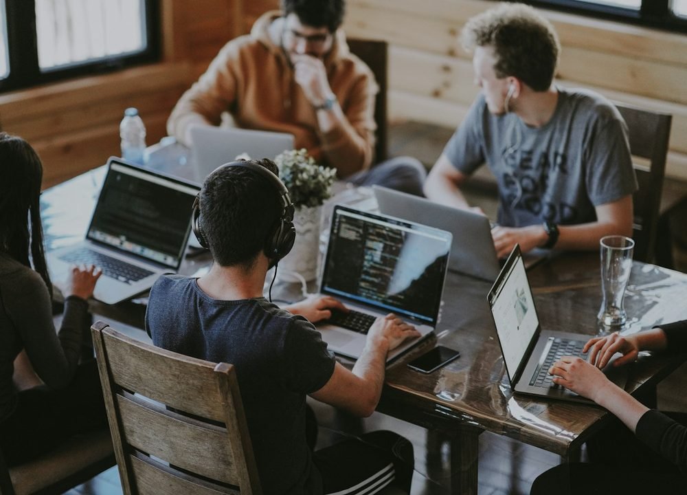 Developers and designers working together on laptops around a table