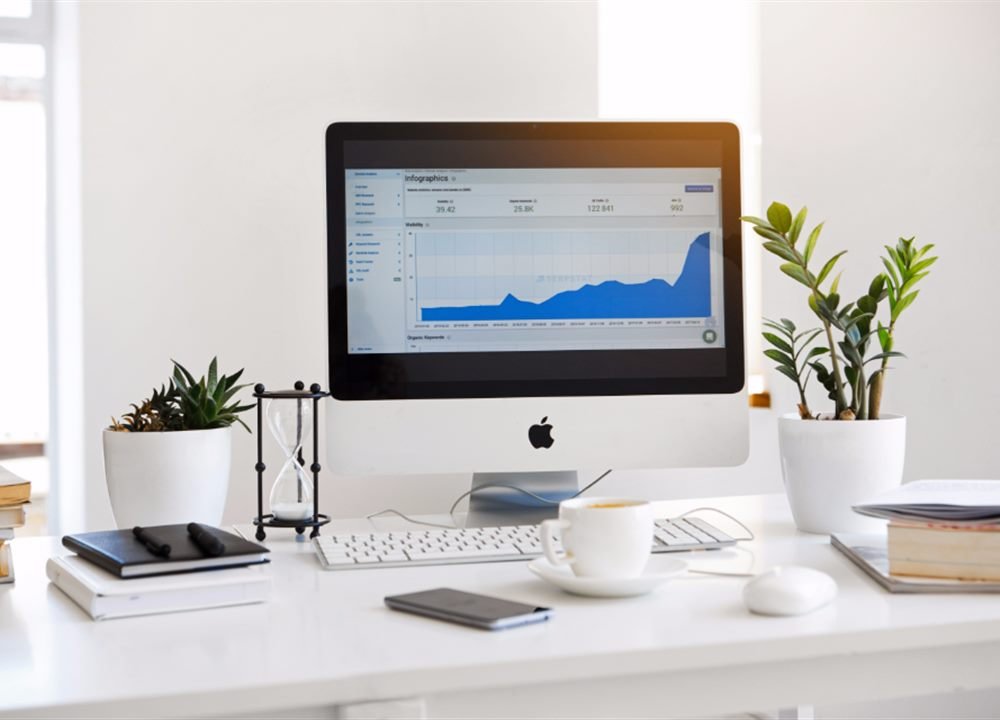 Laptop and monitor showing SEO analytics and traffic charts
